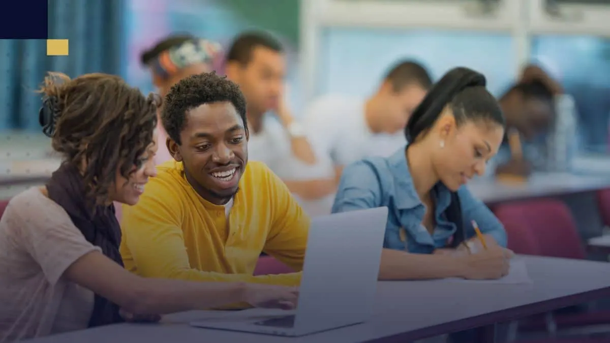 Estudiantes colaborando en clase con laptop y cuadernos para redactar textos argumentativos usando conectores