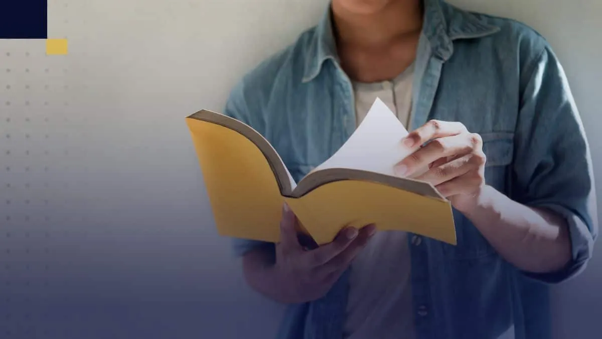 Estudiante revisando libro para incluir información en los anexos de un trabajo académico
