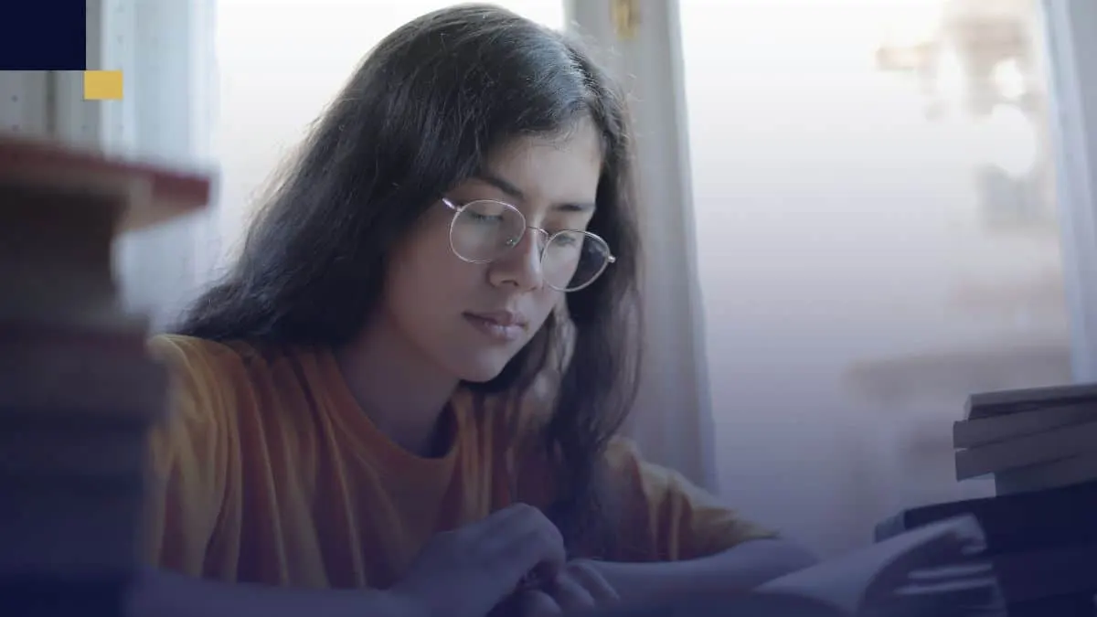 Estudiante leyendo y analizando libros para redactar diferentes tipos de ensayo académico