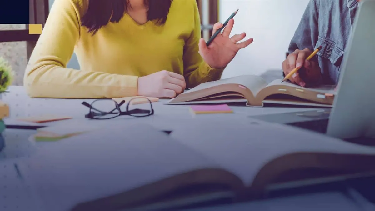 Estudiantes revisando libros y tomando notas para ejemplos de tesis universitarias