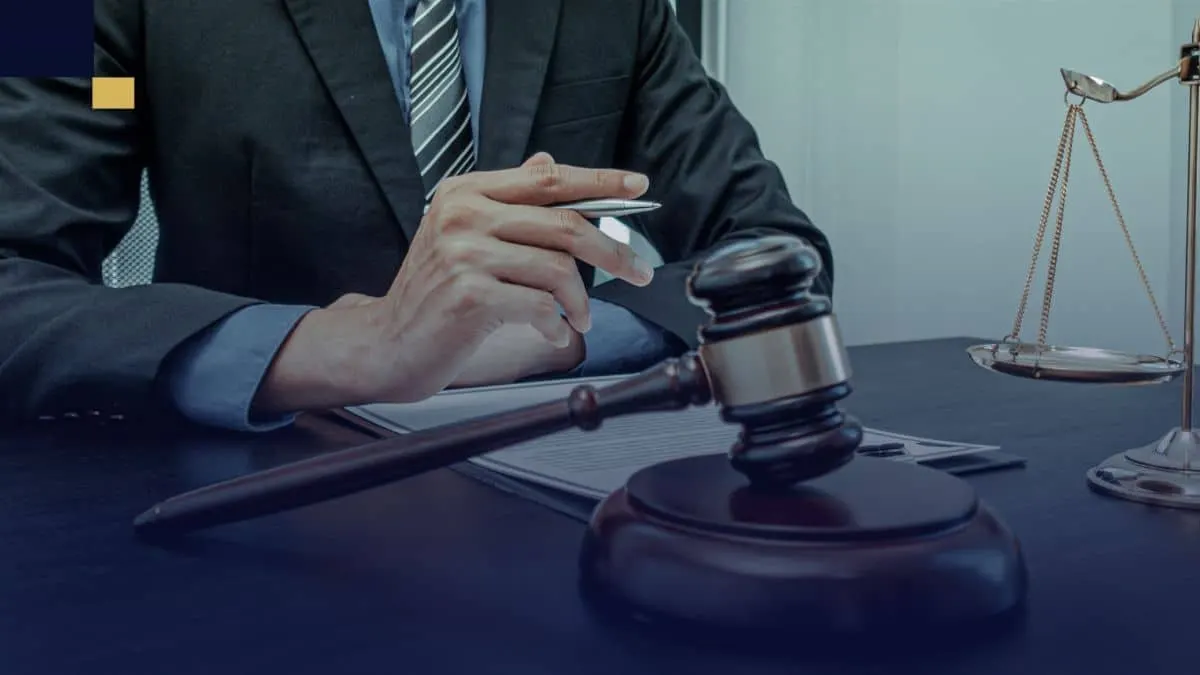 Abogado revisando documentos legales en despacho con mazo y balanza de la justicia.