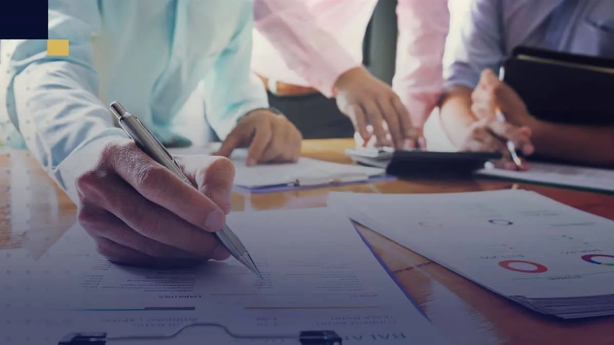 Equipo de profesionales revisando informes y gráficos financieros, colaborando en la elaboración de estrategias para un proyecto de Administración Financiera.