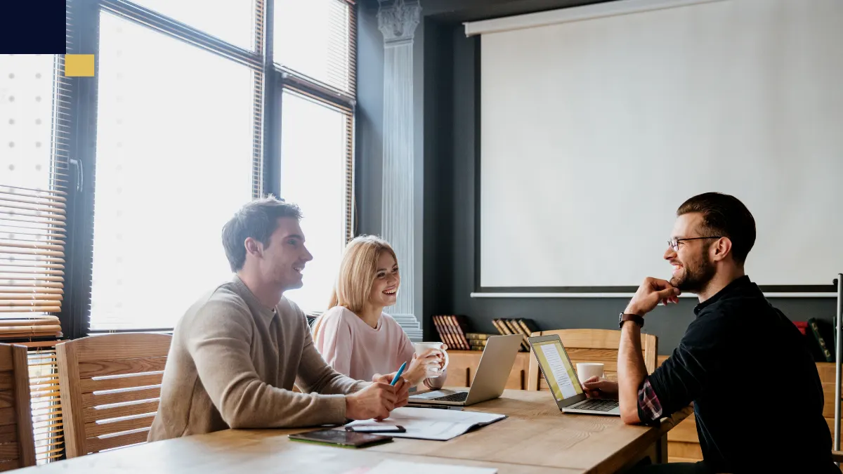 Emprendedor revisando gráficos y documentos en laptop, organizando la estructura y proyecciones de un plan de negocios en su espacio de trabajo.
