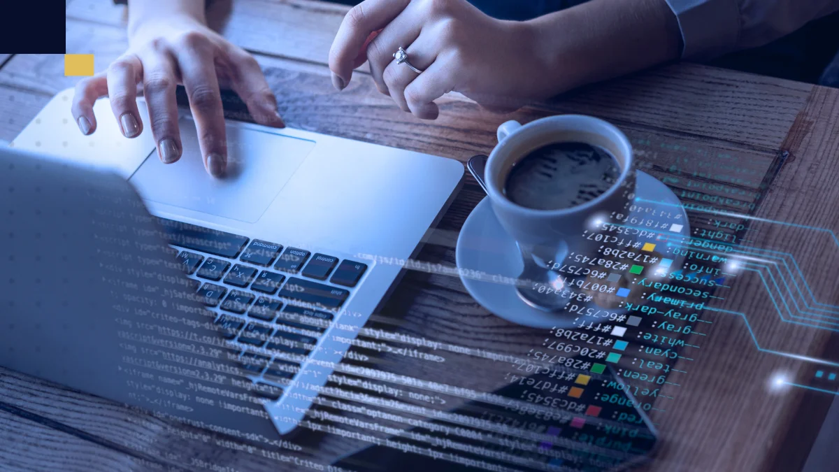 Persona trabajando en una laptop con elementos digitales de programación, imagen de Tesis y Másters Colombia sobre apoyo académico en proyectos universitarios, investigación y desarrollo tecnológico.