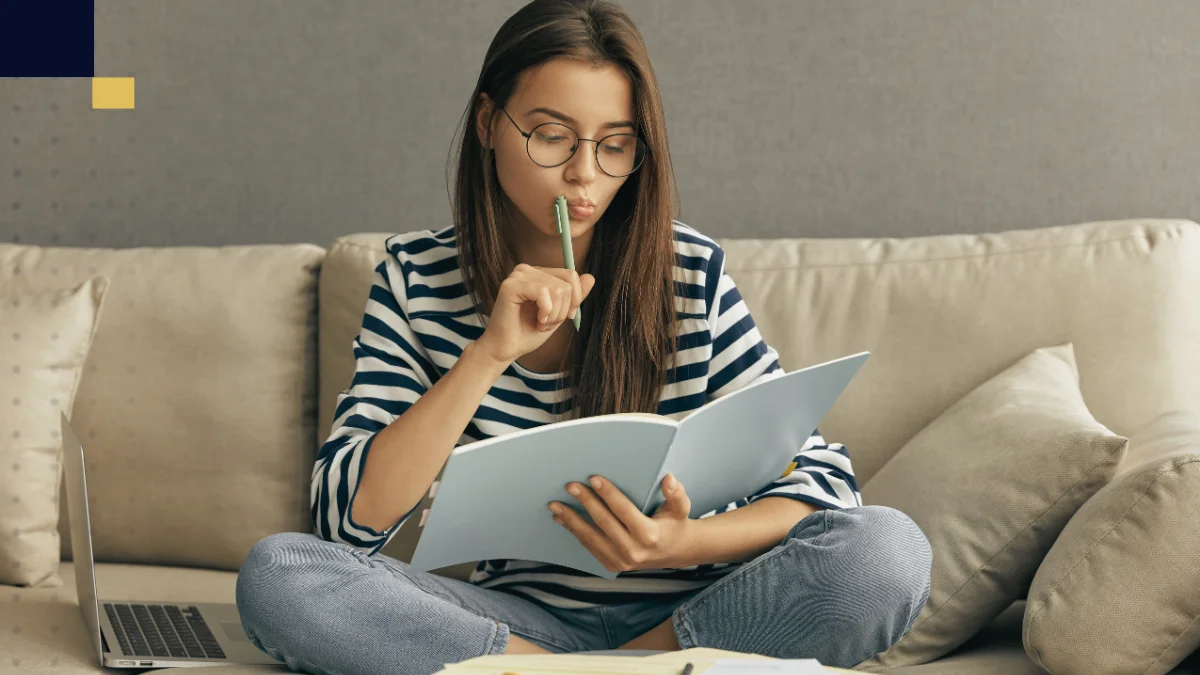 Estudiante revisando apuntes en casa junto a una laptop, imagen de Tesis y Másters Colombia sobre asesoría, corrección y apoyo académico para avanzar con tesis y proyectos universitarios.